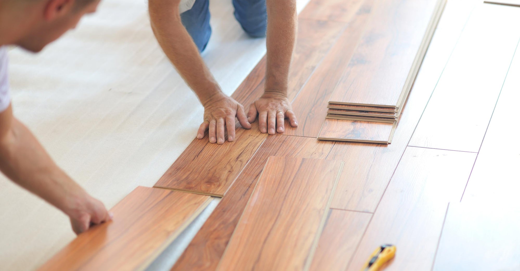 people laying laminate flooring