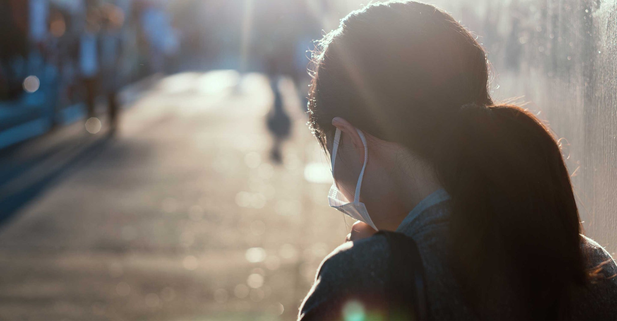 woman from behind wearing face mask outdoors