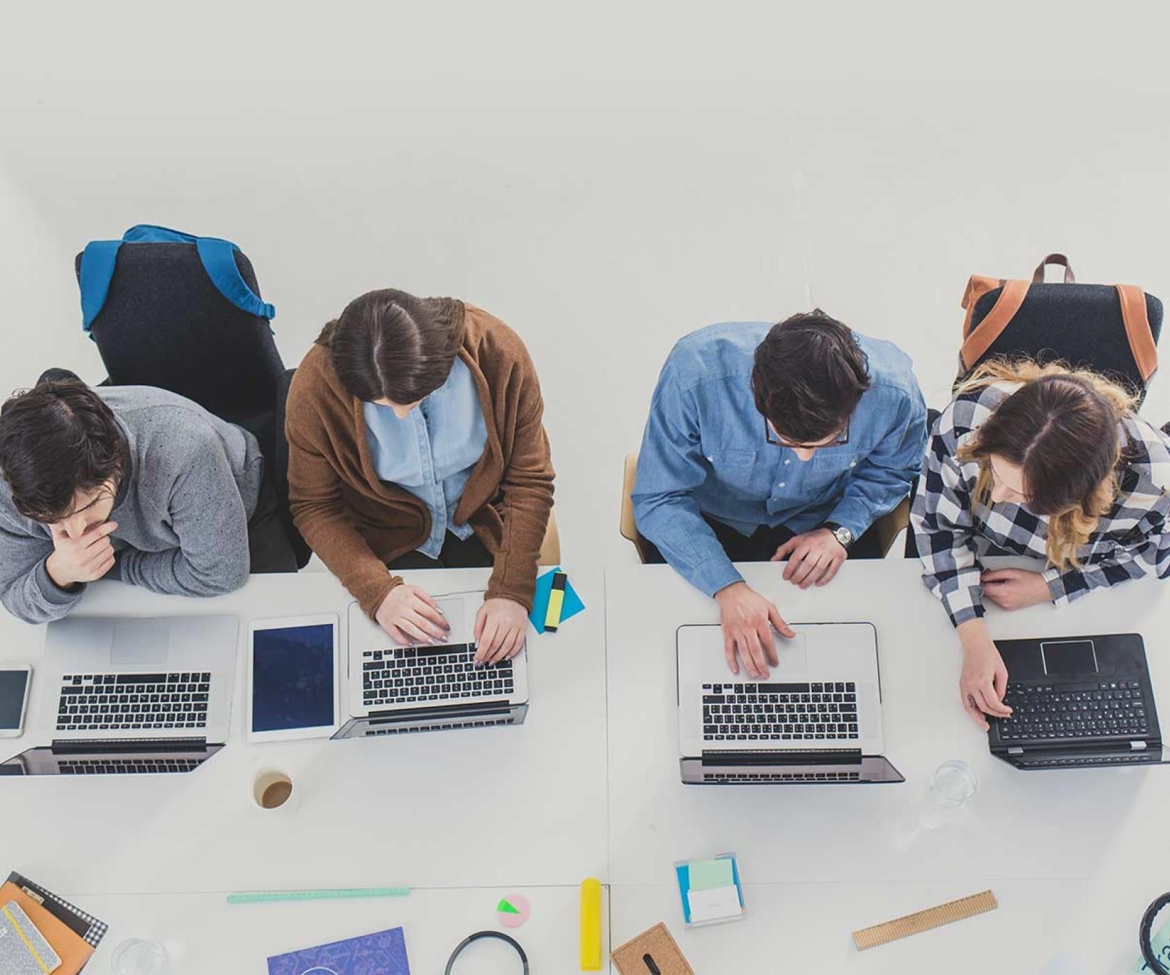 college students overhead working on laptops