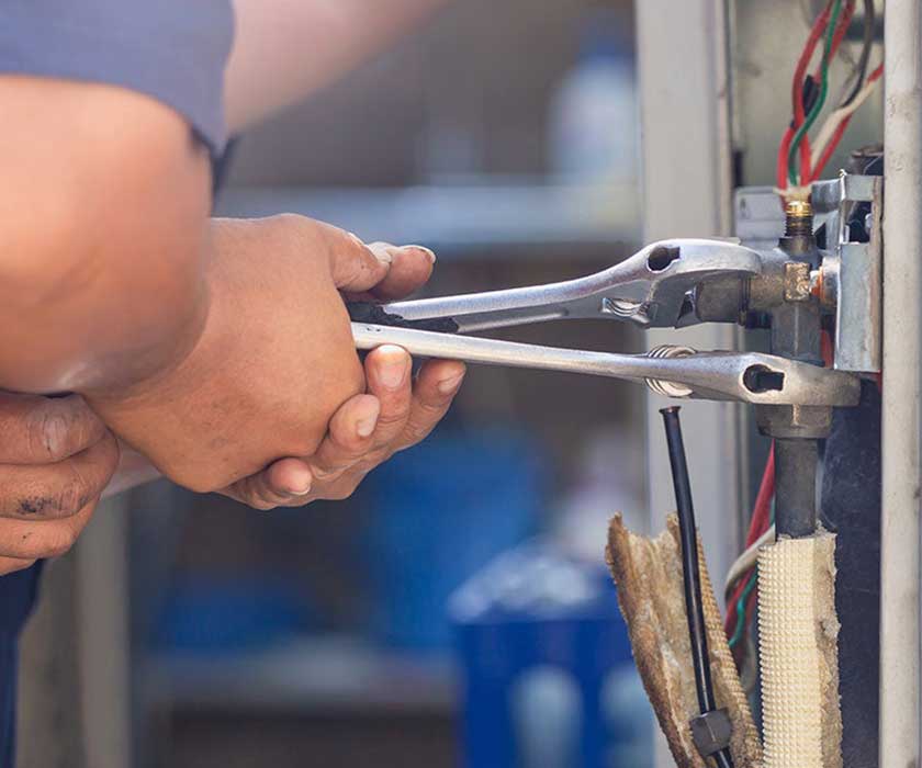 hand holding wrench working on electrical box