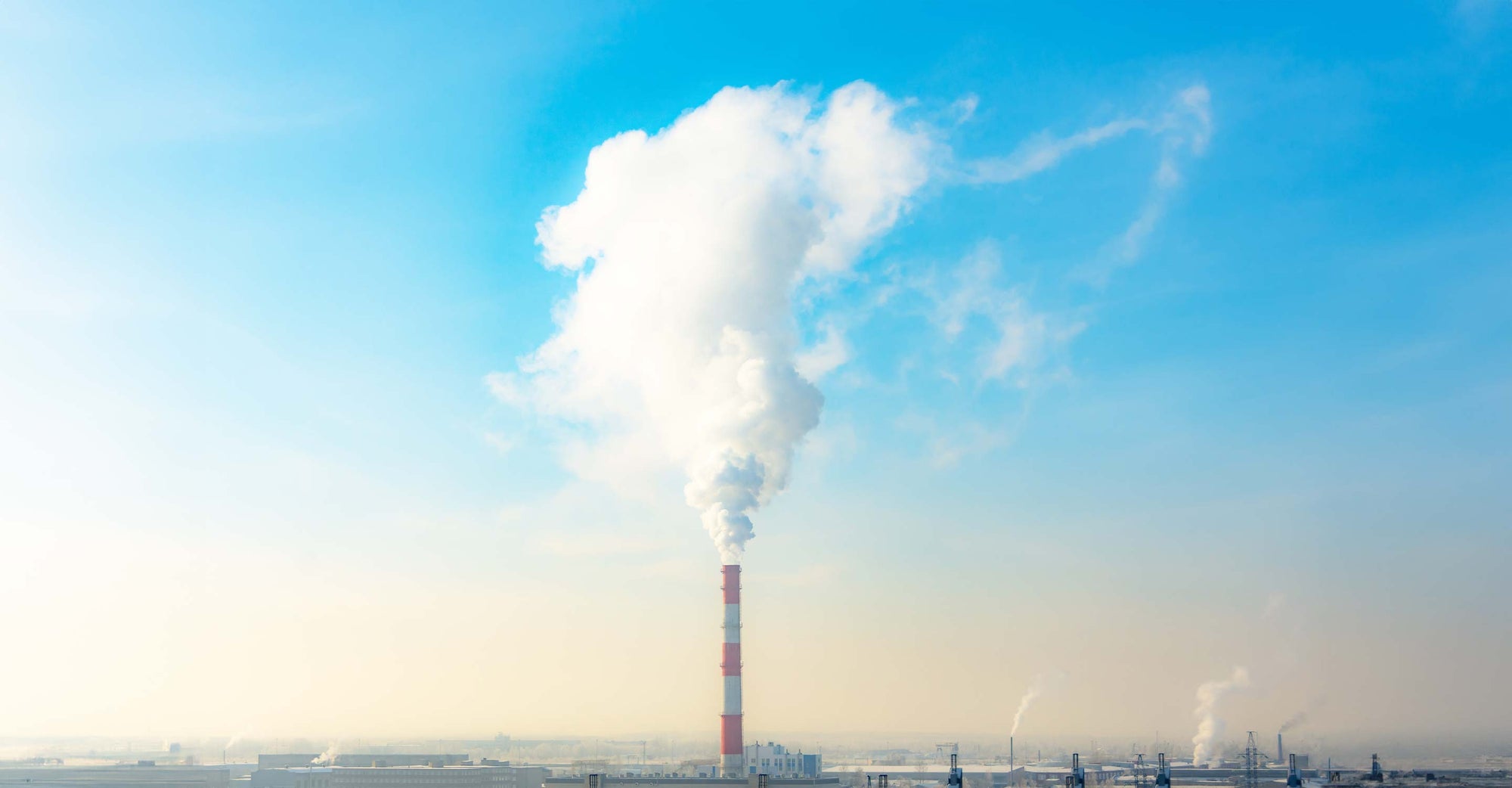 Smoke stack with smoke going in to sky