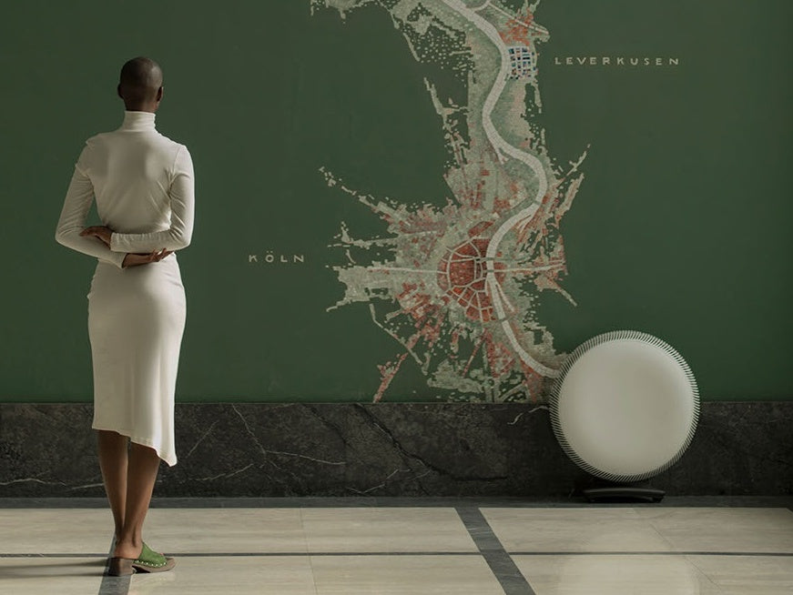 Woman looking at green mural on wall by Atem X